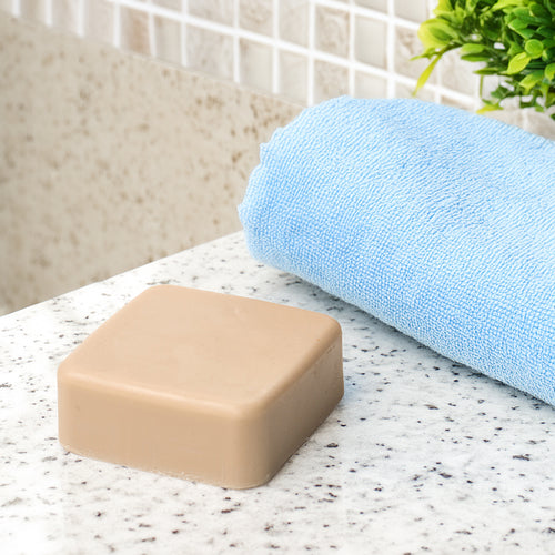 Handcrafted square bay rum soap bar made in USA, featured in Health & Wellness, Grooming and Personal Hygiene, Soaps and Soapmaking, and Best Sellers collections, next to a blue towel.