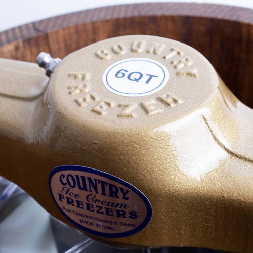 Close-up of a beige metal motor housing embossed with "Country Freezer" and labeled "6QT," part of a handcrafted Lehman's Best Ice Cream Freezers collection in Kitchen & Food, Specialty Equipment, Making Ice Cream, USA Made, and Best Sellers.