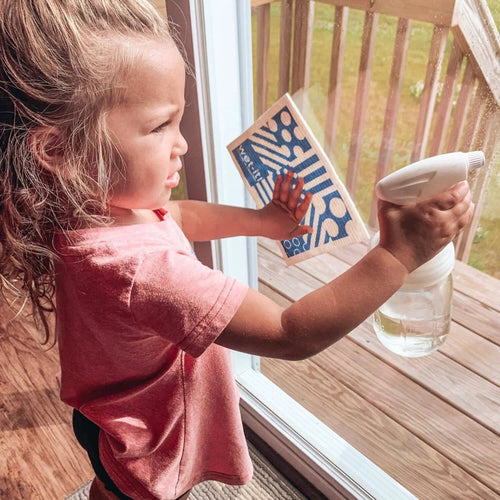 Child using a clear regular-mouth glass jar with a white sprayer lid to clean a window, demonstrating eco-friendly home cleaning tools from Home & Decor, Household Helpers, USA Made collections.