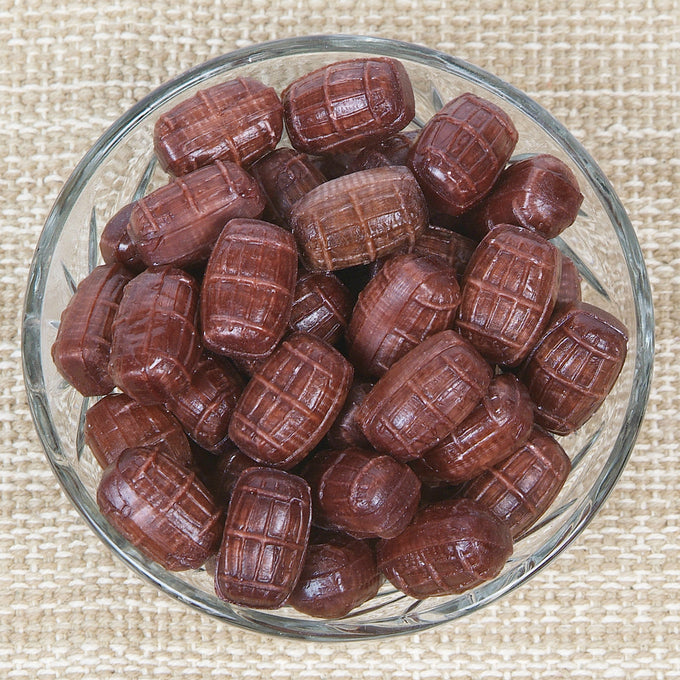 Glass bowl filled with handcrafted hard candies shaped like miniature barrels in rich brown tones, evoking nostalgic flavors from Kitchen & Food, Snacks and Sweets, Best Sellers, and Promo Eligible collections.