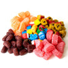 Assortment of colorful nostalgic candies including fruit slices and barrel-shaped chews, evoking sweet memories from classic snack collections in Kitchen & Food, Snacks and Sweets.