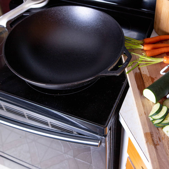 Seasoned cast iron wok with wide, deep bowl-shaped base and side handle, designed for excellent heat retention and balanced cooking, part of Kitchen & Food, Cookware, Cast Iron, USA Made, and Best Sellers collections.