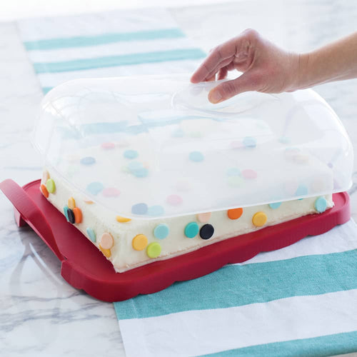 Clear domed reversible carrier with scalloped red edges and snap-lock handles, holding a rectangular cake decorated with colorful round confetti, suitable for Kitchen & Food and Baking Supplies collections.