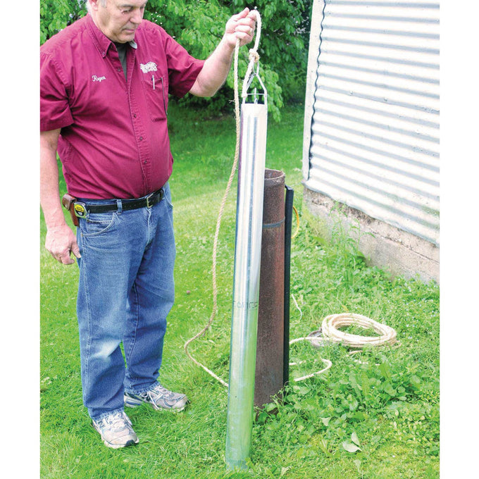 Man outdoors holding a long galvanized steel well bucket with a rope, demonstrating its use for water retrieval in farm, garden, emergency supplies, and best sellers collections.