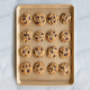 Natural aluminum baking sheet with premium gold nonstick coating, holding sixteen freshly baked chocolate chip cookies sprinkled with sea salt, ideal for Kitchen & Food, Cookware, Baking Supplies, USA Made, Best Sellers, and Promo Eligible collections.