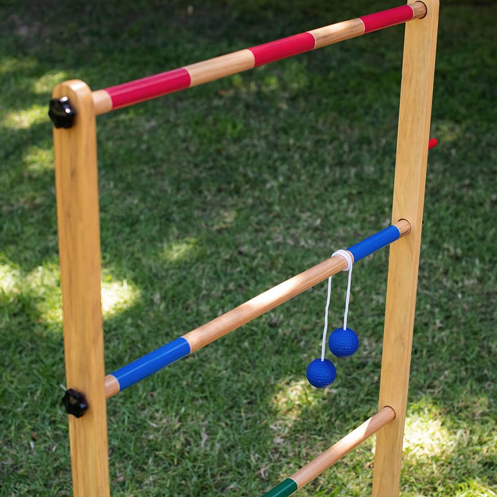 Handcrafted wooden ladder frame with natural finish and red and blue painted rungs, featuring two blue golf ball bolas hanging by white cords, part of Toys, Books & Games, Lawn Games, Best Sellers, and Promo Eligible collections.