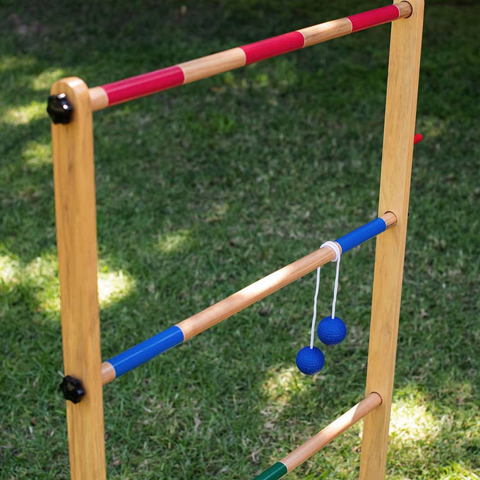 Handcrafted wooden ladder frame with natural finish and red and blue painted rungs, featuring two blue golf ball bolas hanging by white cords, part of Toys, Books & Games, Lawn Games, Best Sellers, and Promo Eligible collections.