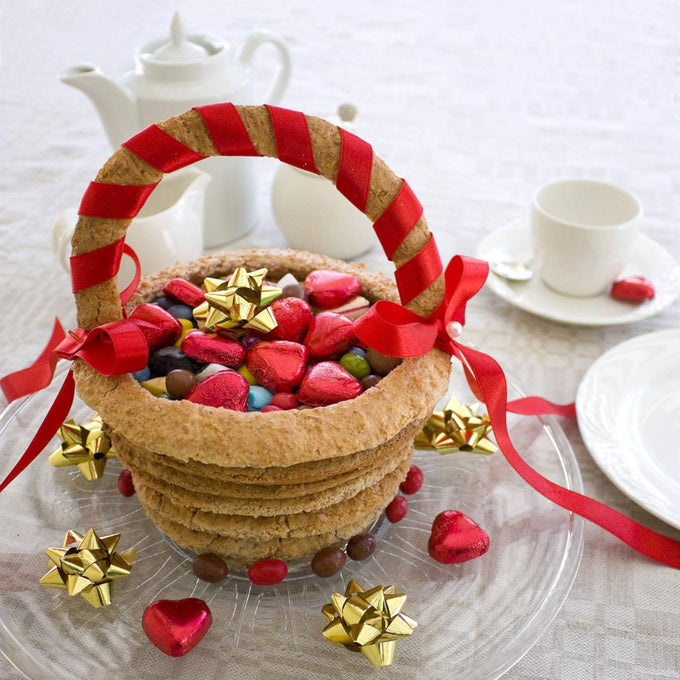 Stacked layered ring cake basket with red ribbon handle filled with heart-shaped chocolates and colorful candies, styled on a table with white porcelain tea set, ideal for Kitchen & Food, Cookware, Baking Supplies, Pots and Pans, Best Sellers, and Promo Eligible collections.