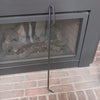 Hand-forged steel fire poker with a loop handle, crafted by Amish artisans in the USA, designed for safe log adjustment and ember stirring in hearths and stoves.