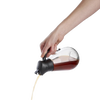 Clear glass syrup dispenser with black gravity lid pouring syrup smoothly, designed for easy storage and serving, featured in Kitchen & Food, Storage and Serving, and Best Sellers collections.