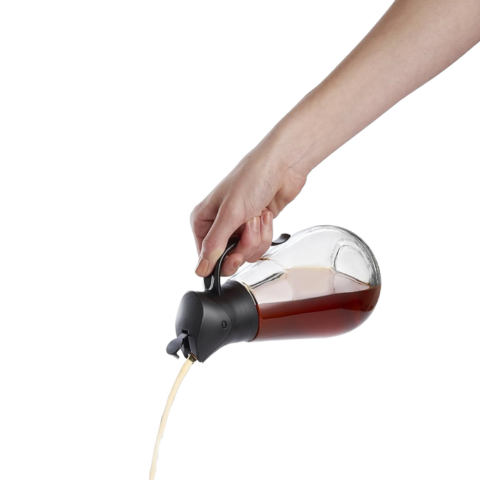 Clear glass syrup dispenser with black gravity lid pouring syrup smoothly, designed for easy storage and serving, featured in Kitchen & Food, Storage and Serving, and Best Sellers collections.