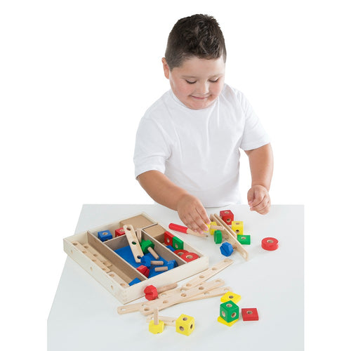 Child engaged in indoor play with a wooden construction building set featuring colorful nuts, bolts, blocks, and a child-size screwdriver from a handcrafted Toys, Books & Games collection.