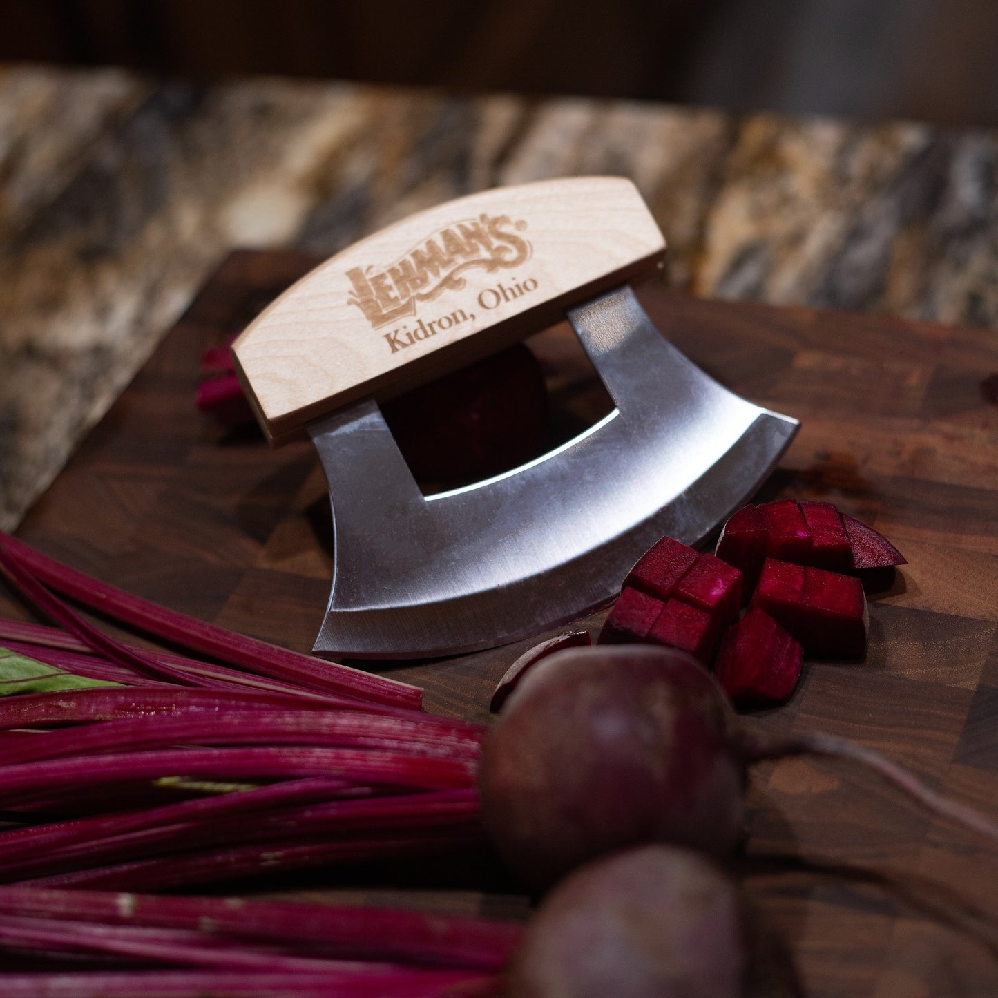 Handcrafted Ulu knife with wooden handle and sharp crescent blade resting on a wooden cutting board, shown with freshly diced beets, perfect for Kitchen & Food and Food Prep collections.
