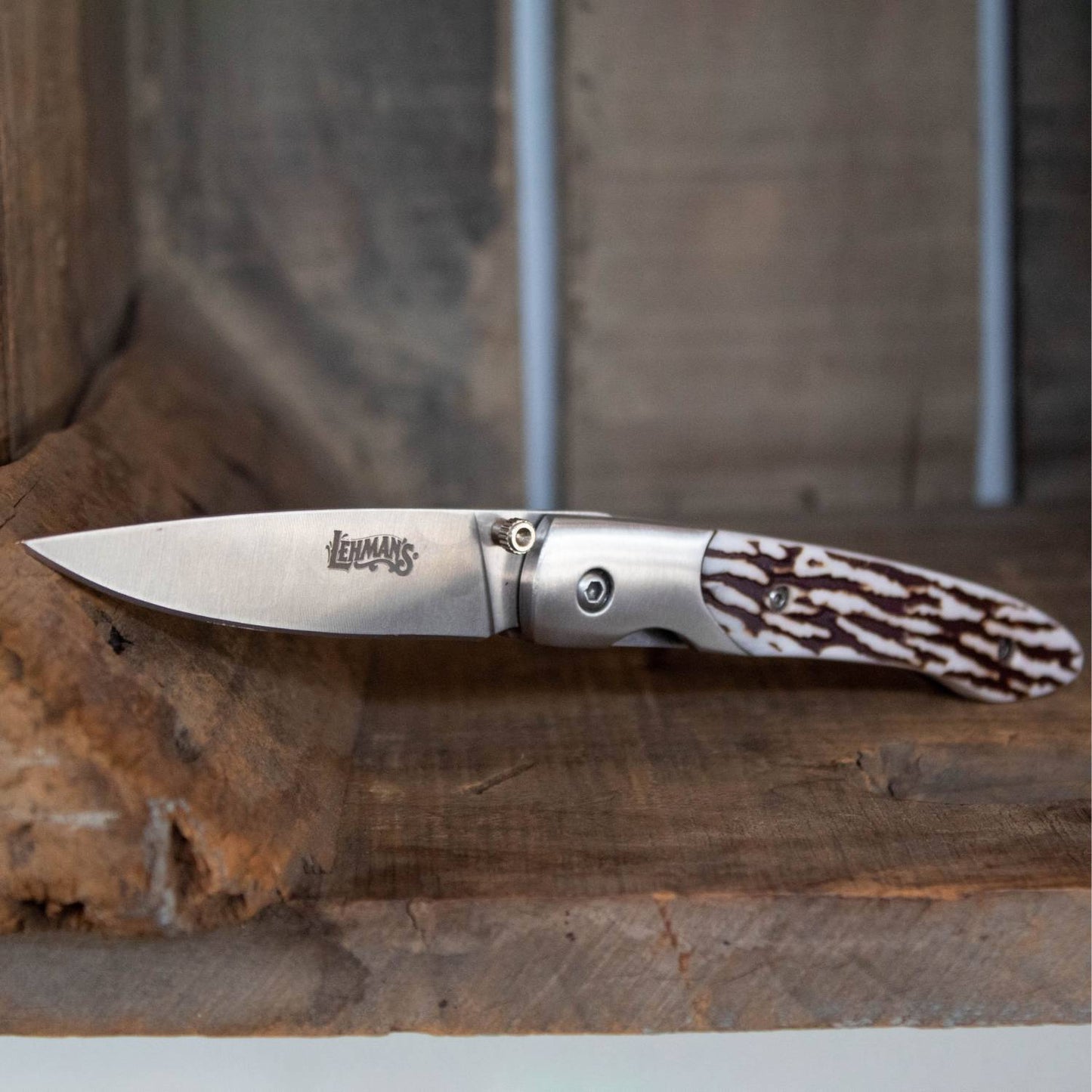 Lockback folding knife with a stainless steel blade engraved with Lehman's logo and a textured antler handle, handcrafted for Farm, Garden & Tool and Pocket Knives collections.