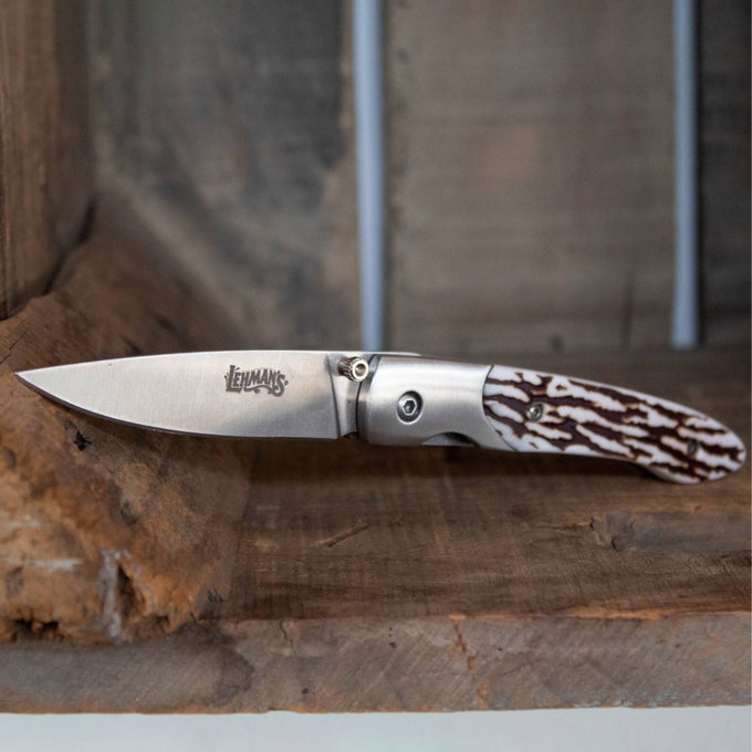 Lockback folding knife with a stainless steel blade engraved with Lehman's logo and a textured antler handle, handcrafted for Farm, Garden & Tool and Pocket Knives collections.
