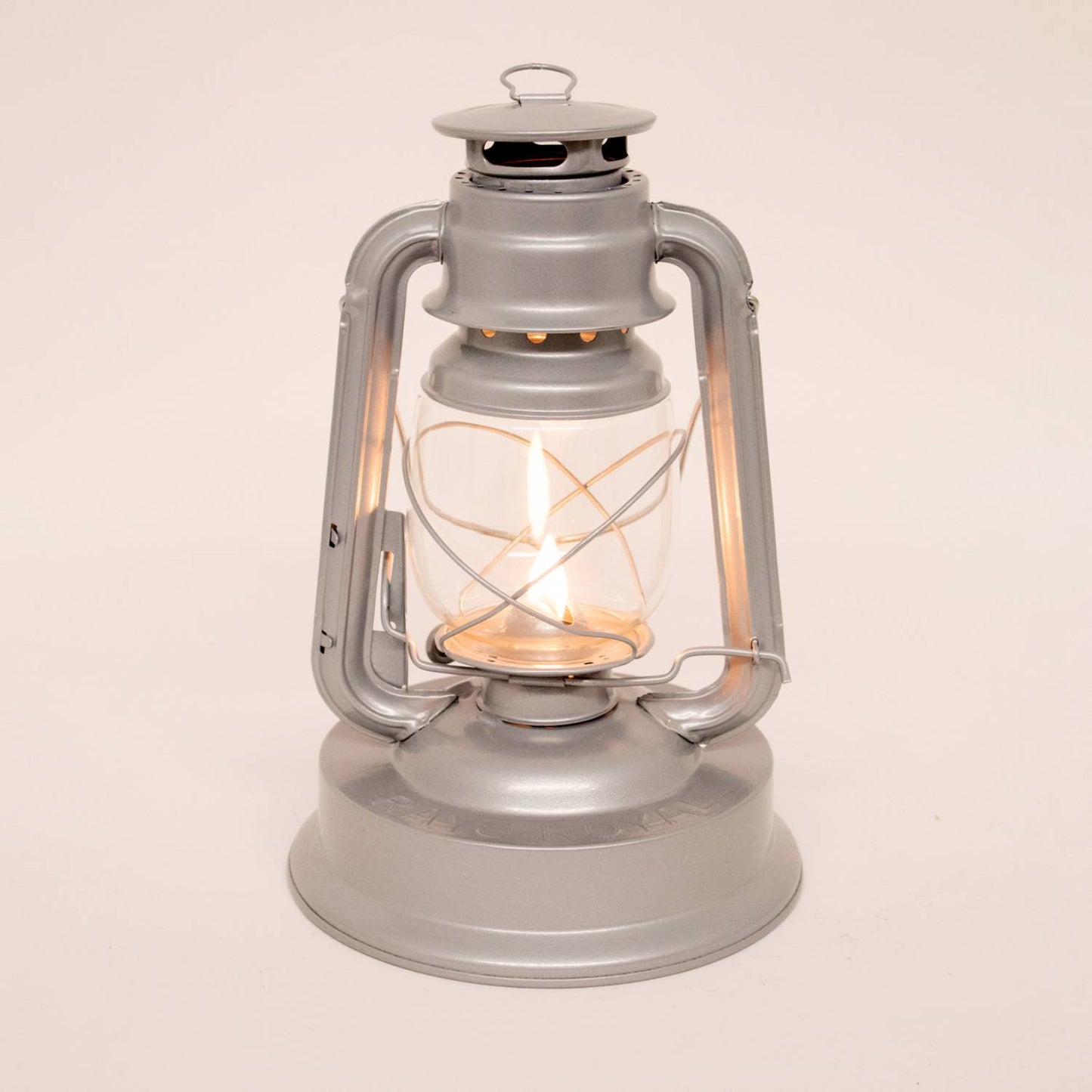Handcrafted gray metal lantern with glass globe and protective wire frame, burning a bright flame, ideal for farm, garden, camping, emergency supplies, and outdoor use.