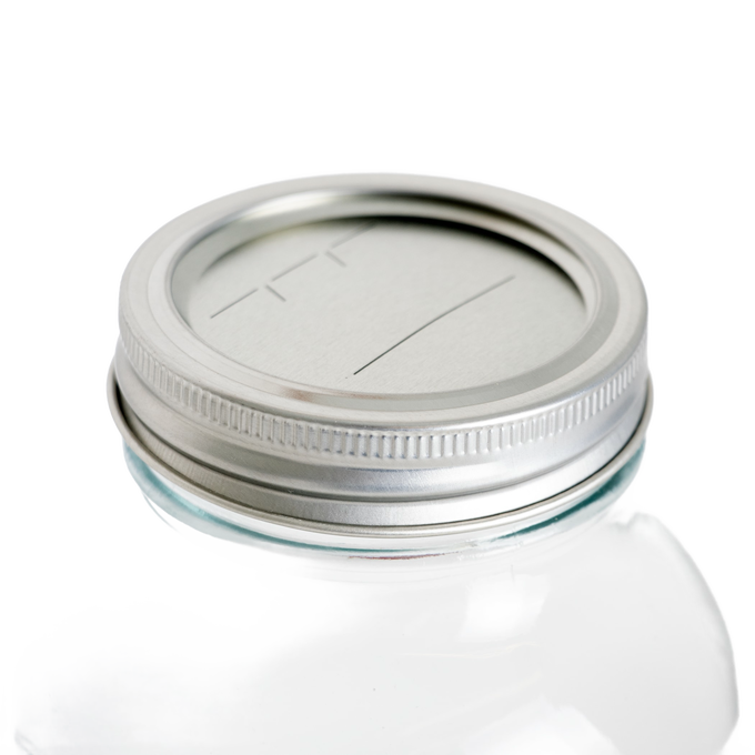 Silver metal lid and band with BPA-free sealing compound fitted on a regular-mouth glass jar, ideal for Kitchen & Food, Food Preservation, and Canning collections.