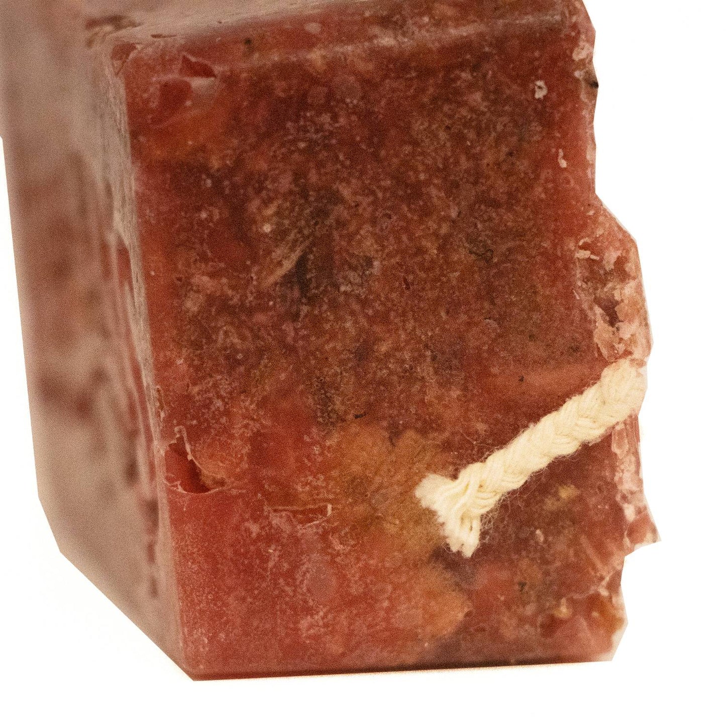 Close-up of a handcrafted reddish-brown fire starter block with a thick natural wick, made in the USA for quick, non-toxic fire lighting in wood stoves, camping, and hearth accessories collections.