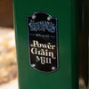 Close-up of green metal grain mill with polished metal badge reading "Lehman's Power Grain Mill," highlighting handcrafted Amish-made quality, suitable for Farm, Garden & Tool and Bread Making Supplies collections.