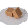 Two pieces of creamy handcrafted fudge resting on a white paper doily, showcasing rich, smooth texture, ideal for Kitchen & Food, Snacks and Sweets, and Best Sellers collections.