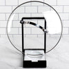 Two-in-one kitchen gadget with black plastic frame and white porcelain rest holding a glass pot lid upright, designed to keep cooking areas tidy in Kitchen & Food and Kitchen Gadgets collections.
