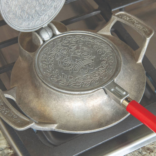 Stovetop iron with aluminum base and red wooden handle, featuring detailed patterned plates for making traditional cookies, crafted in USA for Kitchen & Food and Baking Supplies collections.