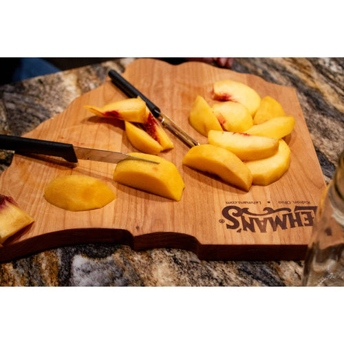 Handcrafted red alder cutting board shaped like Ohio with the Lehman's logo, featuring freshly sliced peaches on a granite countertop, part of Kitchen & Food and Food Prep collections.