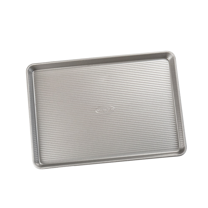 Durable aluminized steel half sheet pan with ribbed surface for even heat distribution, ideal for baking cakes, jelly rolls, and roasting vegetables, part of Kitchen & Food and USA Made collections.