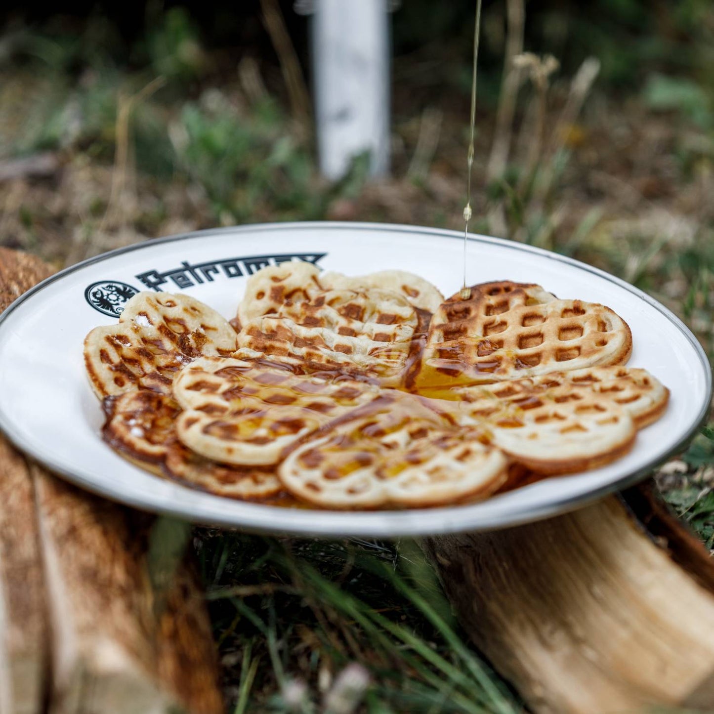 White enamel plate with black rim and Petromax logo holding heart-shaped waffles drizzled with syrup, crafted for outdoor use in Farm, Garden & Tool, Kitchen & Food, Camping, Dinnerware, Best Sellers, and Promo Eligible collections.