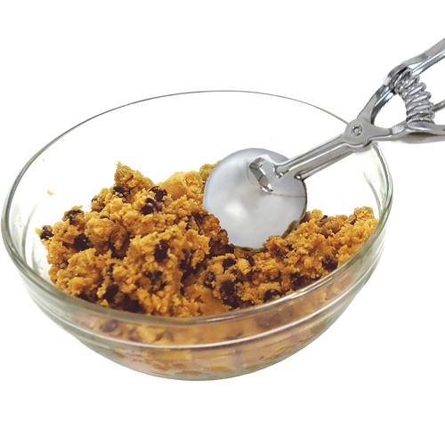 Metal scoop with a spring handle extracting cookie dough from a clear glass bowl, ideal for Kitchen & Food, Bakeware, and Best Sellers collections, handcrafted quality.