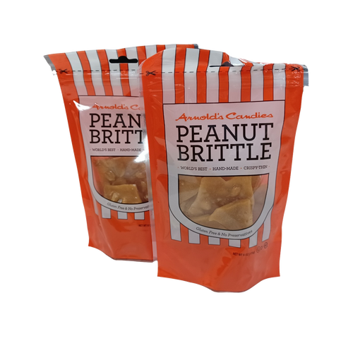 Two resealable orange and white striped bags of handmade peanut brittle featuring gluten-free and preservative-free labels, perfect for Kitchen & Food and USA Made collections.