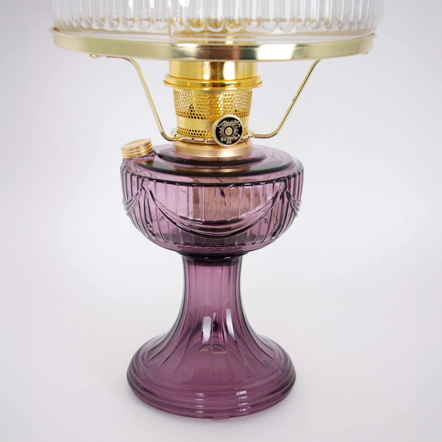 Handcrafted oil lamp with a deep amethyst glass base and polished brass burner, featuring a clear ribbed top shade, bright for reading and suitable for Farm, Garden & Tool, Lamps & Lighting, Emergency Supplies, Oil Lamps, Table Lamps, Best Sellers, and Promo Eligible collections.