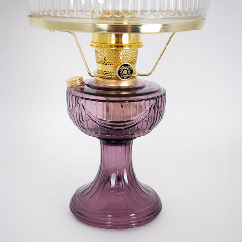 Handcrafted oil lamp with a deep amethyst glass base and polished brass burner, featuring a clear ribbed top shade, bright for reading and suitable for Farm, Garden & Tool, Lamps & Lighting, Emergency Supplies, Oil Lamps, Table Lamps, Best Sellers, and Promo Eligible collections.