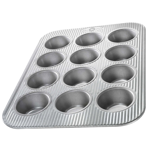 Durable non-stick muffin pan with 12 cups featuring a fluted design for even heating, handcrafted in the USA, ideal for baking, Kitchen & Food, and Cookware collections.