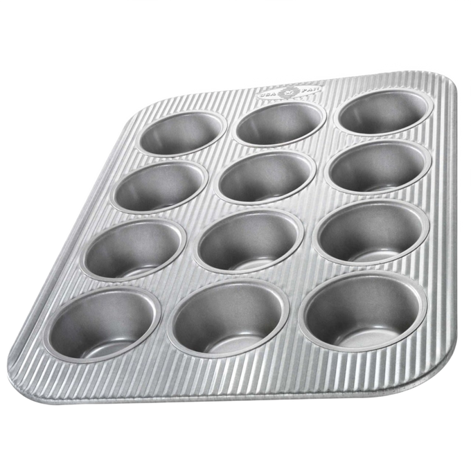 Durable non-stick muffin pan with 12 cups featuring a fluted design for even heating, handcrafted in the USA, ideal for baking, Kitchen & Food, and Cookware collections.