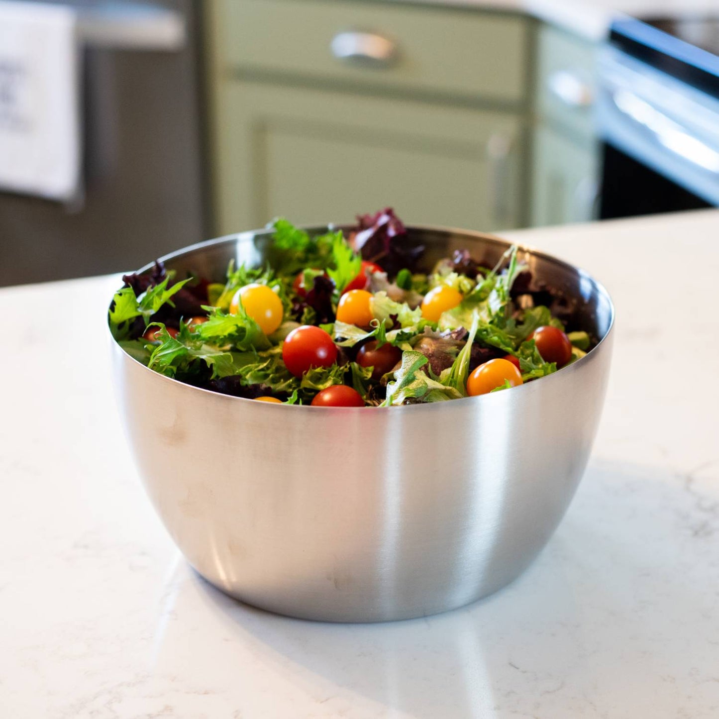 Brushed stainless steel bowl filled with fresh mixed greens and colorful cherry tomatoes, showcased on a kitchen countertop, ideal for Kitchen & Food, Kitchen Gadgets, and Best Sellers collections.