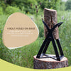 Black metal kindling splitter with wide mouth design holding a thick log upright on a tree stump, featuring four bolt holes for secure mounting, set outdoors in a grassy field.