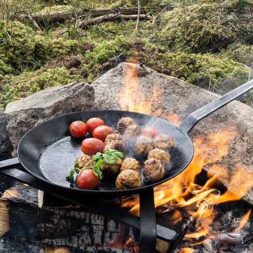 Durable wrought iron pan with long handle cooking meatballs and tomatoes over an open fire in a rustic outdoor setting, ideal for Farm, Garden & Tool, Kitchen & Food, Camping, Cookware, Pots and Pans, Best Sellers, and Promo Eligible collections.