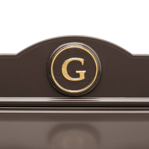 Close-up of a handcrafted bronze and gold wall mount mailbox featuring a personalized gold letter monogram on a round medallion, made in USA for Home & Decor and Mailboxes collections.