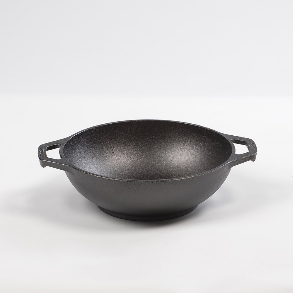 Handcrafted cast iron mini wok with flat bottom and sloped sides, featuring loop handles, pre-seasoned for nonstick cooking and compatible with all stovetops, part of USA Made cookware collections.