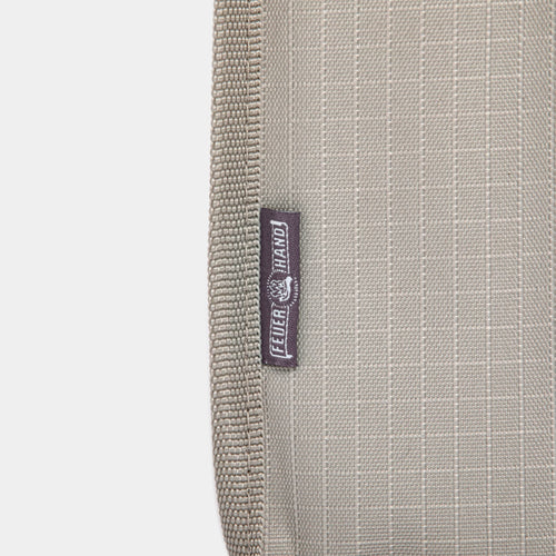 Close-up of a beige padded nylon transport bag with reinforced stitching and a small fabric label, designed for safely carrying lanterns in camping and emergency supplies collections.