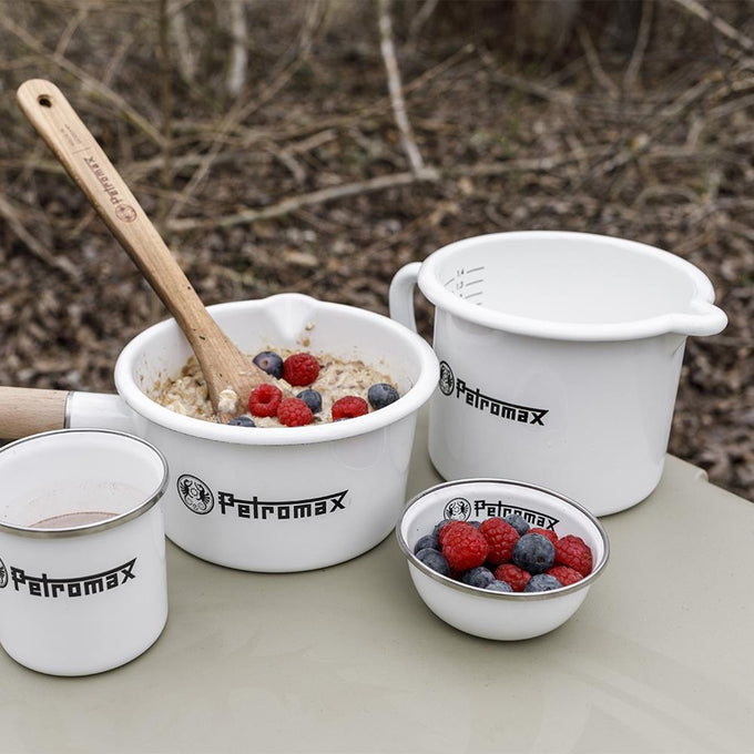 Set of white enameled steel cookware including a milk pot with spout, a bowl of oatmeal with berries and wooden spoon, a small bowl with berries, and a cup, handcrafted for Farm, Garden & Tool, Kitchen & Food, Camping, Cookware, Pots and Pans, Best Sellers, and Promo Eligible collections.