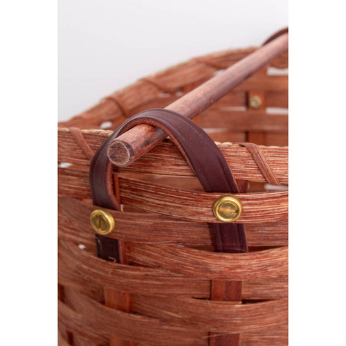 Close-up of a handwoven maple wood toilet paper holder basket featuring a birch dowel rod and leather handles with brass rivets, handcrafted in the USA; ideal for Home & Decor and Household Helpers collections.
