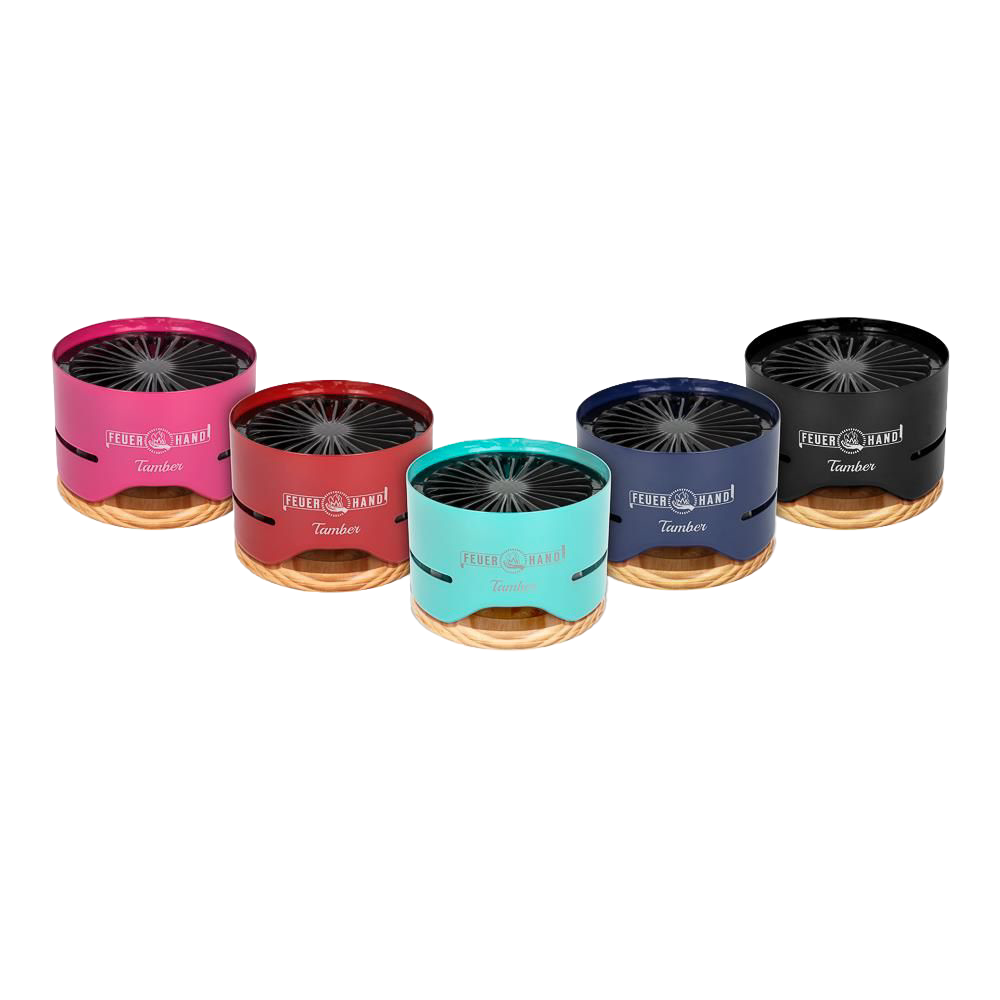 Row of five compact tabletop charcoal grills in pink, red, turquoise, blue, and black finishes with wooden bases, designed for small outdoor cooking, featured in Farm, Garden & Tool and Grilling collections.