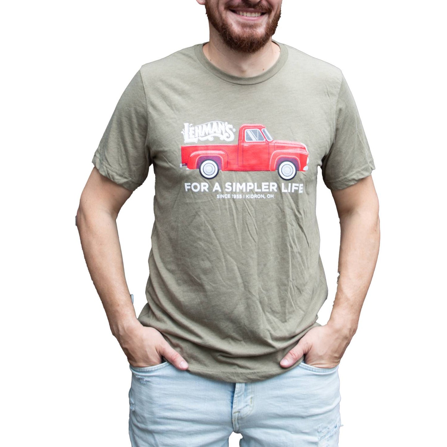 Adult wearing an olive handcrafted soft cotton t-shirt featuring a bright red classic truck graphic with Lehman's logo and "For a Simpler Life" text, perfect for Health & Wellness, Clothing and Accessories, Best Sellers, and Promo Eligible collections.