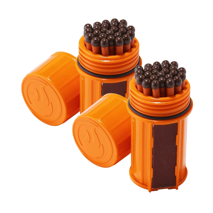 Two orange waterproof containers each filled with tightly packed brown-headed matches and equipped with built-in striking surfaces, designed for reliable outdoor use in camping and emergency supplies.