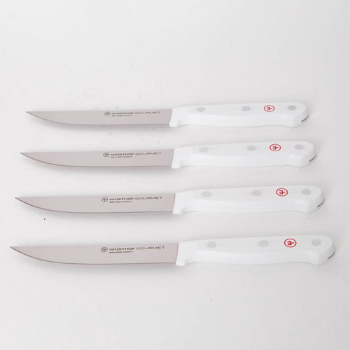 Four white-handled kitchen knives with stainless steel blades, featuring ergonomic grips and stamped logos, ideal for precision food prep in Kitchen & Food and Knives & Axes collections.