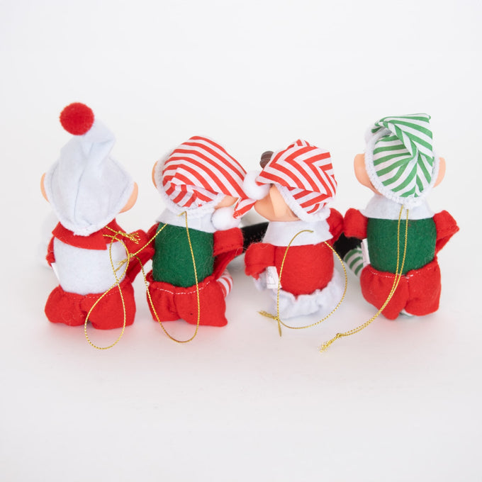 Group of four posable fabric elves with striped and solid hats in red, green, and white, each featuring a gold hanging cord, displayed as holiday decor in seasonal and best sellers collections.