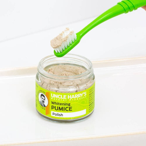 Green toothbrush holding natural pumice polish powder above a small glass jar labeled for teeth whitening, featured in Health & Wellness, Grooming and Personal Hygiene, USA Made, and Best Sellers collections.