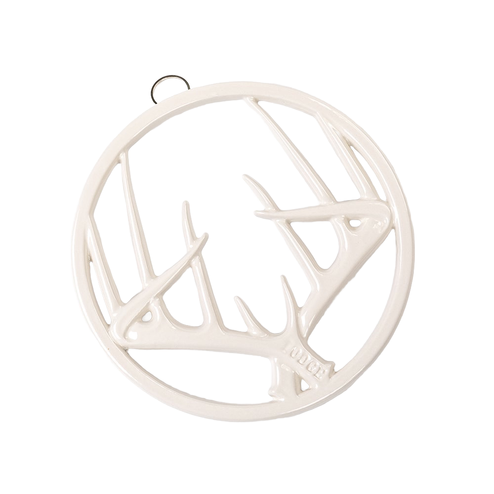 Off-white enamel trivet with an antler motif, featuring durable chip-resistant finish, rubber feet for stability, and a built-in hanger, ideal for Kitchen & Food, Dinnerware, Storage and Serving, Best Sellers, and Promo Eligible collections.